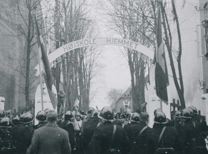 På billedet ses Højskolehjemmets indkørsel den 8. december 1940, tidligere på dagen. Situationen er gengivet fra politiets synsvinkel - med nazisterne stående over for, nogle med hævede spader. Foto (C): Rigsarkivet